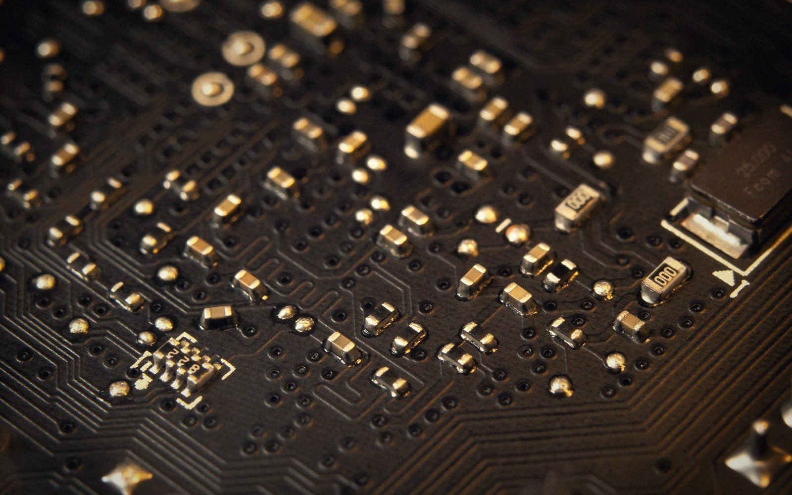 Close-up of surface-mount resistors, capacitors and a crystal oscillator on a circuit board