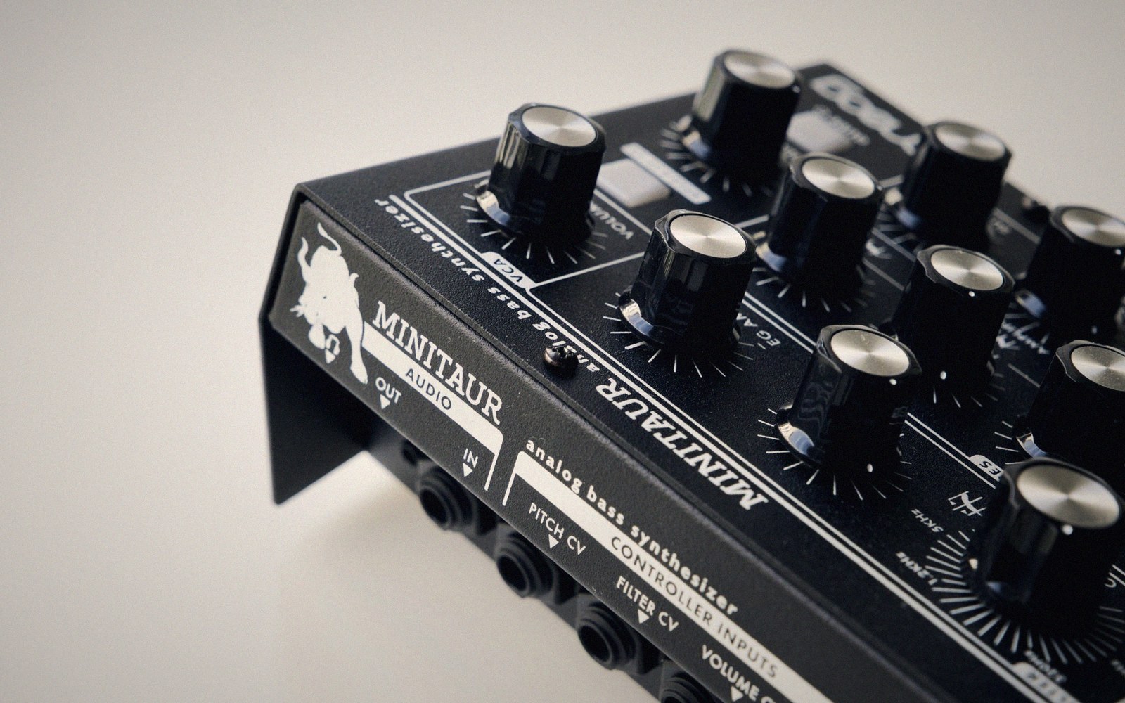 Close-up of a Moog Minitaur analog bass synthesizer with black knobs and input jacks